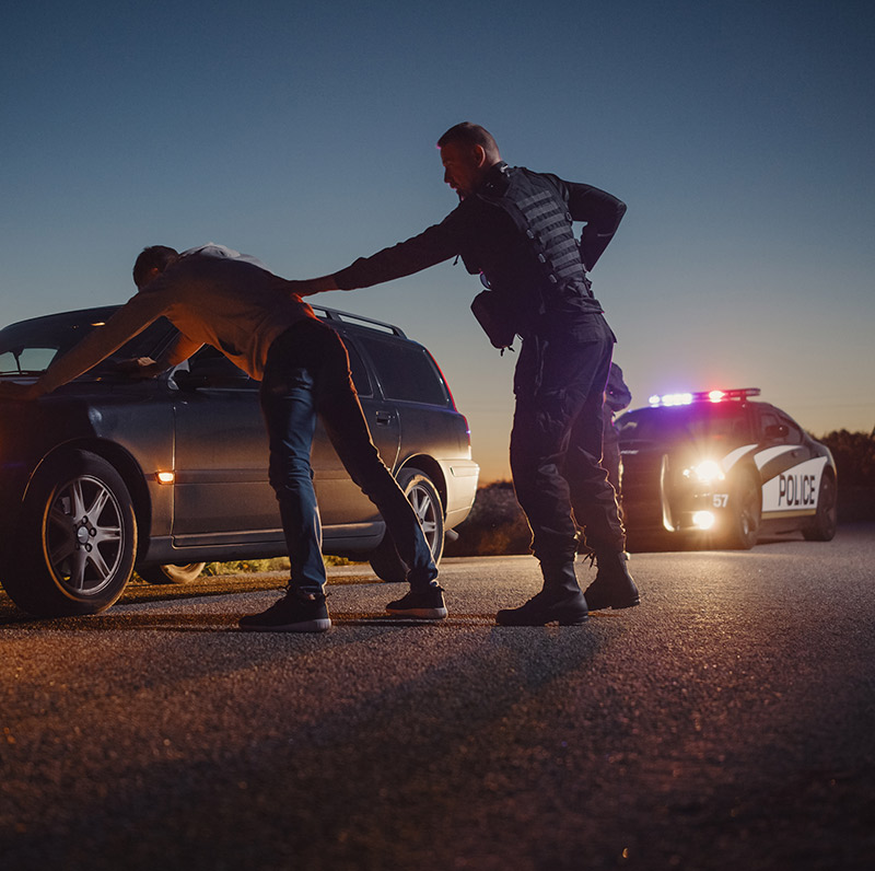 Man being arrested by his car